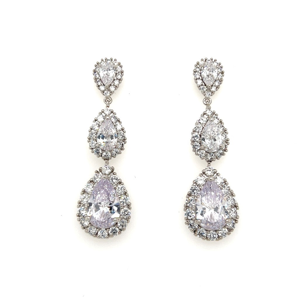 The Glam Triple Drop CZ Bridal Earrings (style no. E159) feature three teardrop-shaped clear stones on each earring, each encircled by a halo of sparkling CZs and displayed against a white background.