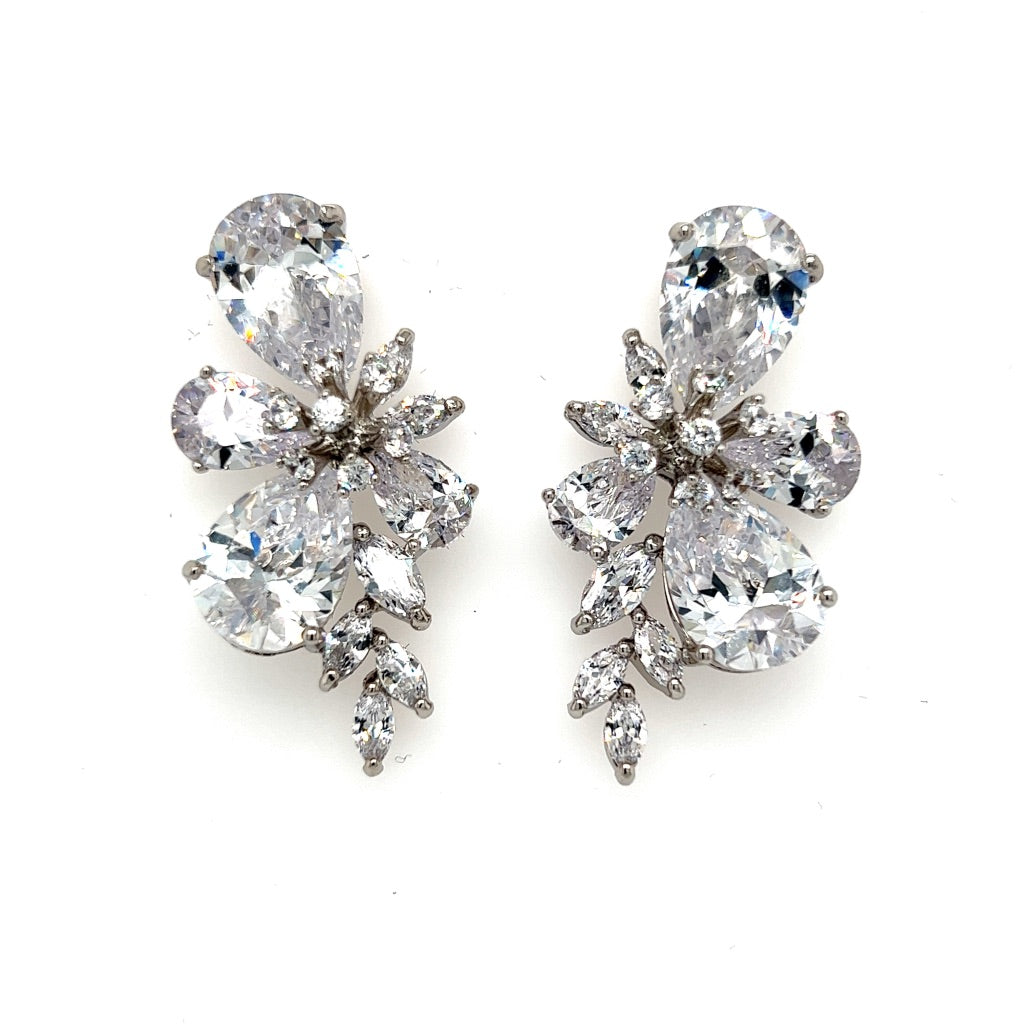 The Floral Cluster CZ Drop Earrings (style no. E180) feature elegant silver-tone settings with clear teardrop and marquise-shaped cubic zirconia in a floral, leaf-inspired design, shown on a white background.