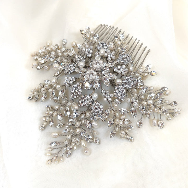 The Floral Crystal and Pearl Hair Comb (style no. 242716) is an ornate Swarovski crystal hair comb with a floral design, adorned with pearls and sparkling clear crystals.