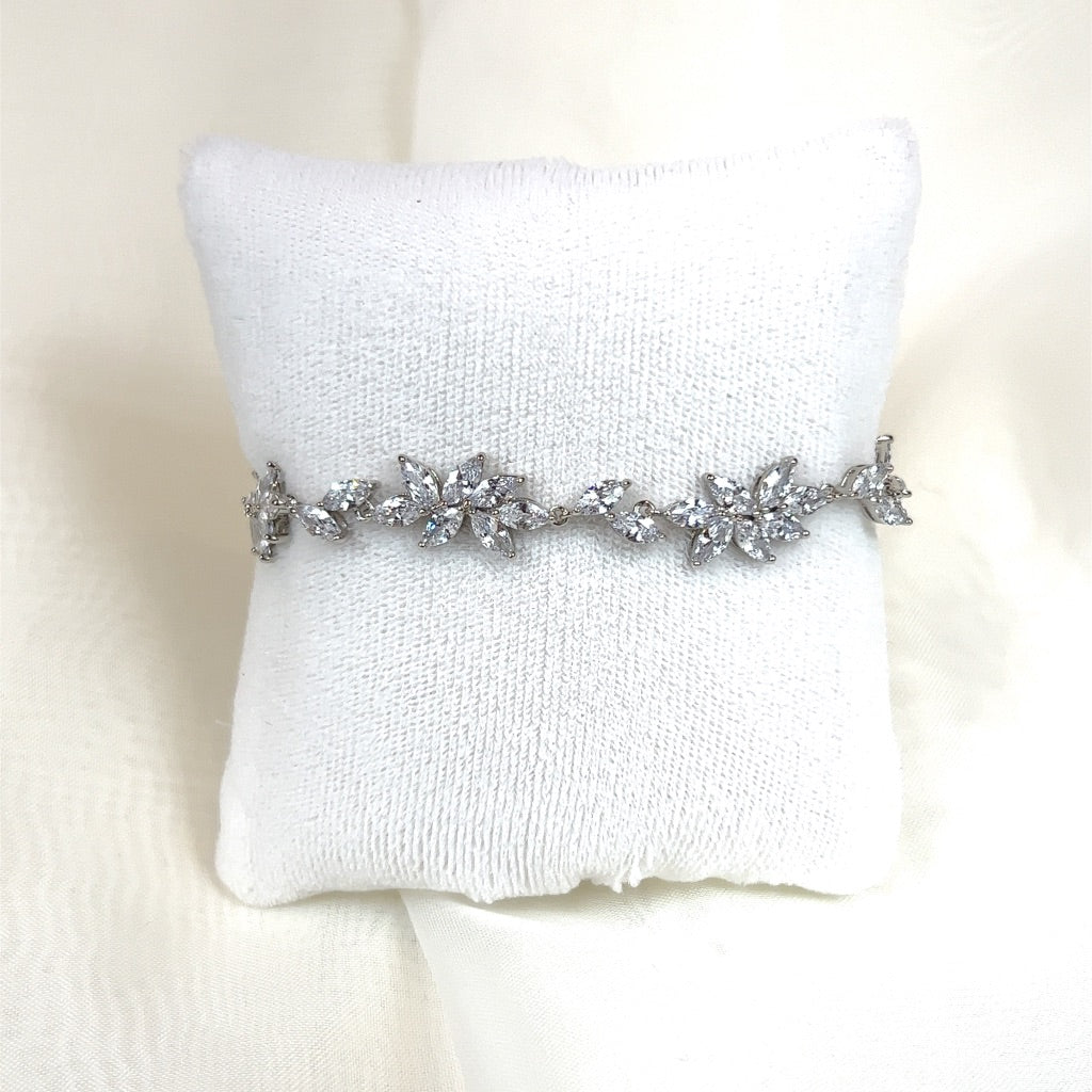 The Delicate Floral Cluster Wedding Bracelet (style no. B148) is elegantly presented on a small white cushion against a light background