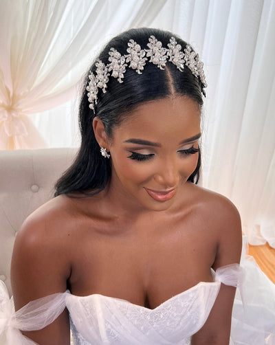 female model wearing pointed bridal headband with crystalized floral details and pearls