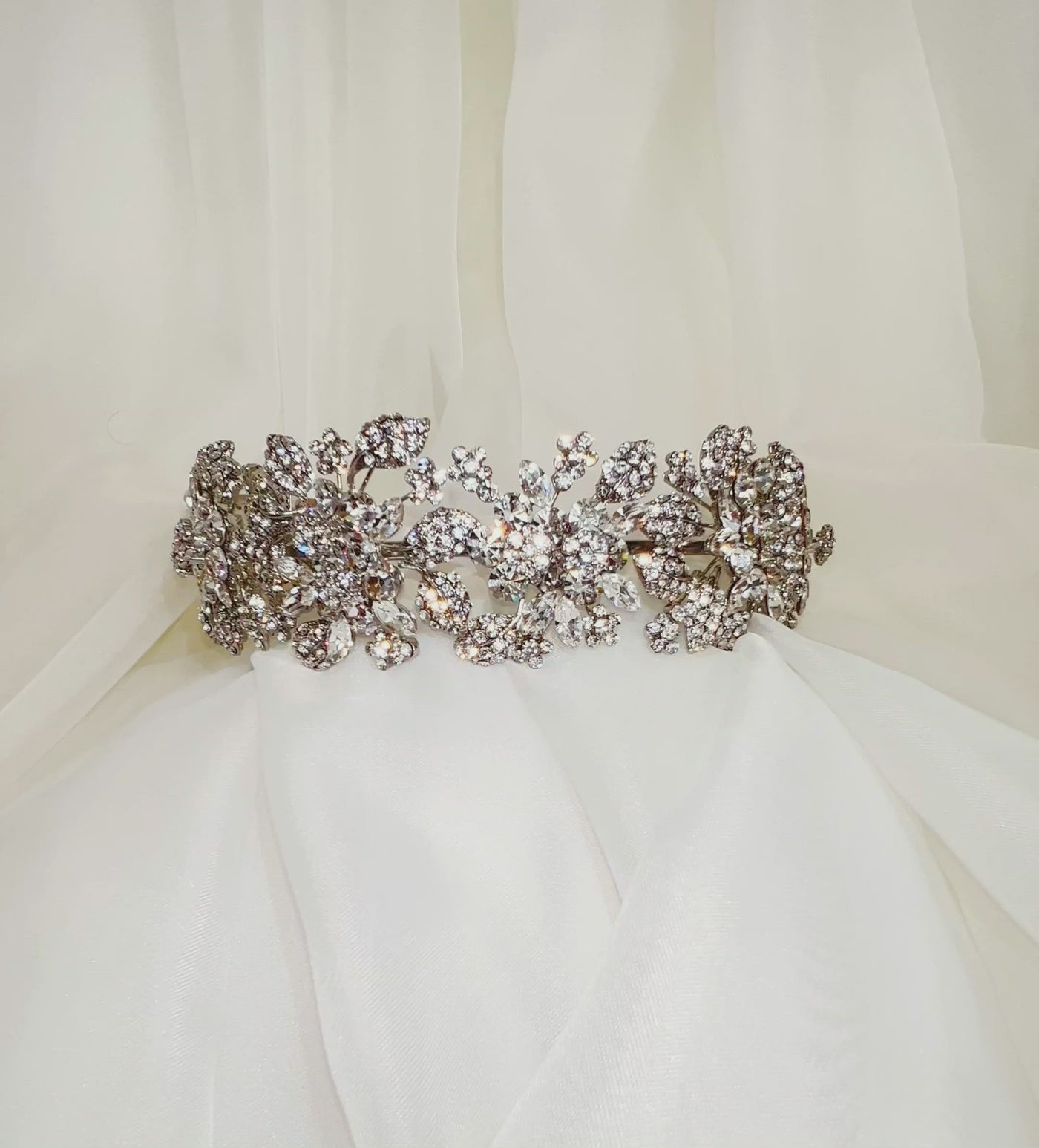silver bridal headband with various crystal flowers and sparkling clusters